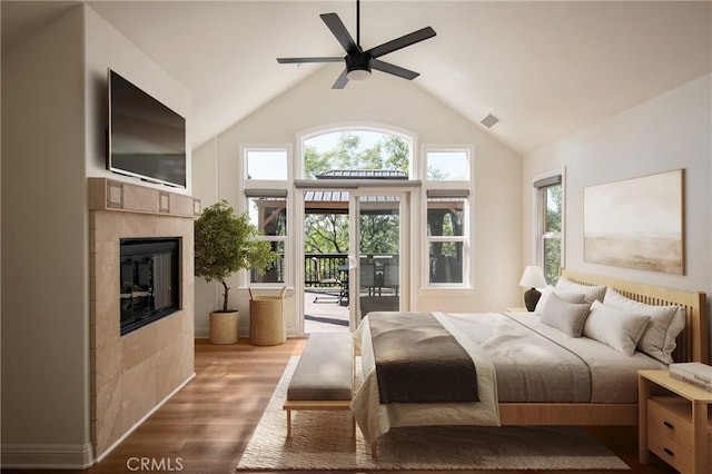 bedroom with a fireplace, lofted ceiling, light hardwood / wood-style flooring, ceiling fan, and access to exterior