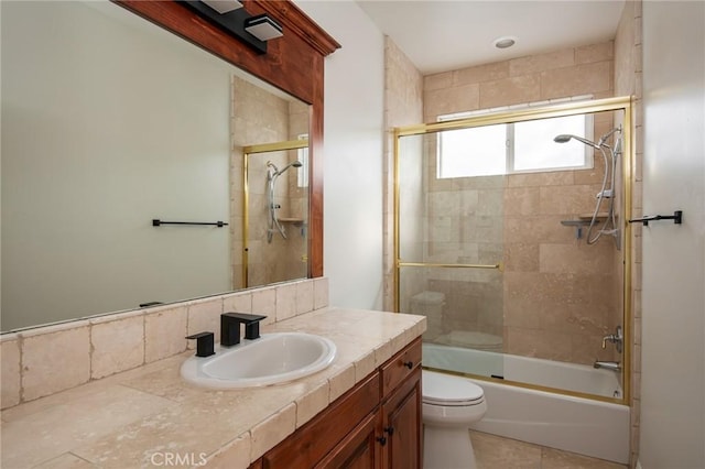 full bathroom featuring tile patterned flooring, bath / shower combo with glass door, vanity, and toilet