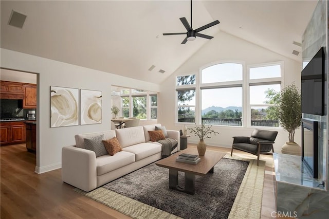 living room with dark wood-type flooring, ceiling fan, and a fireplace