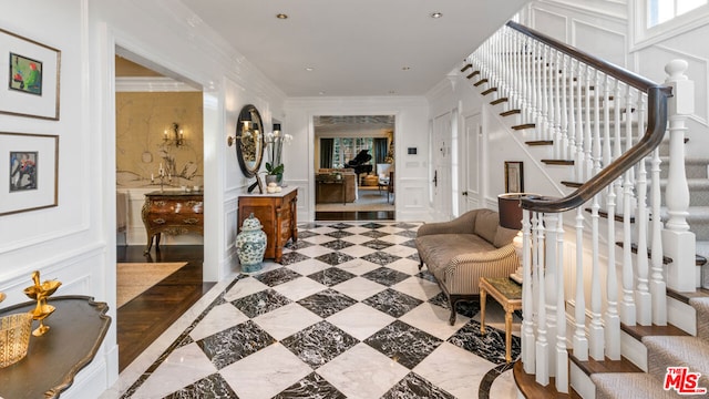 foyer entrance featuring crown molding