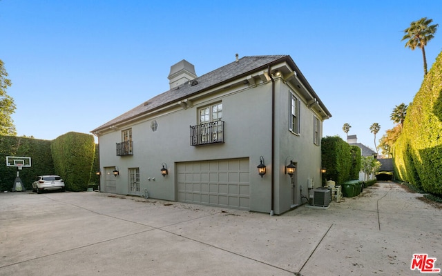 view of side of property featuring a garage and central air condition unit