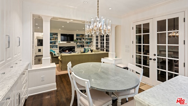 dining space featuring built in features, decorative columns, dark hardwood / wood-style floors, ornamental molding, and french doors