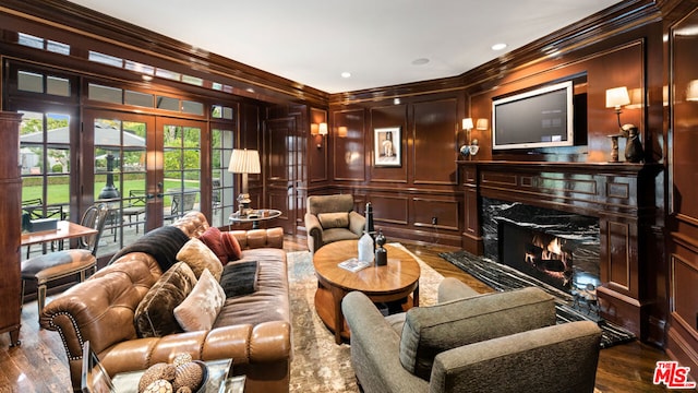 cinema room featuring dark hardwood / wood-style flooring, ornamental molding, a premium fireplace, and french doors