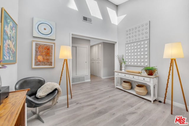 office area featuring light hardwood / wood-style flooring and a high ceiling