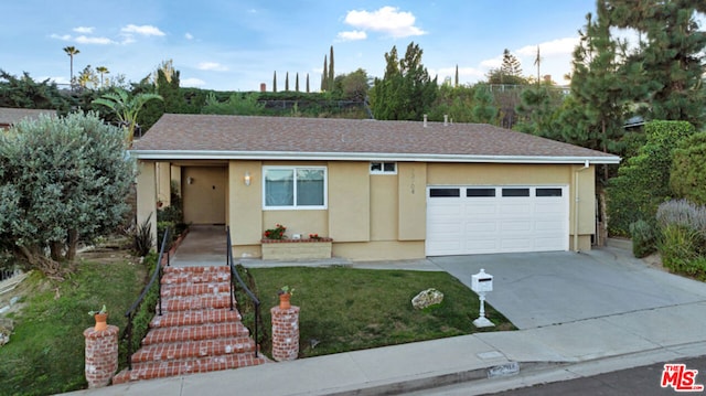 ranch-style home featuring a garage and a front lawn