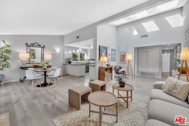 living room with light hardwood / wood-style flooring and a skylight