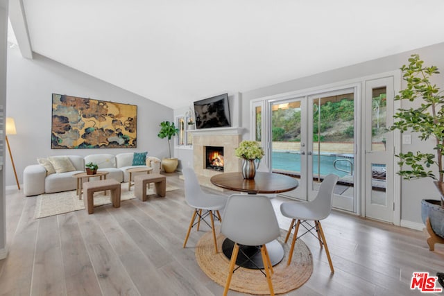 dining area featuring lofted ceiling, light hardwood / wood-style floors, and french doors