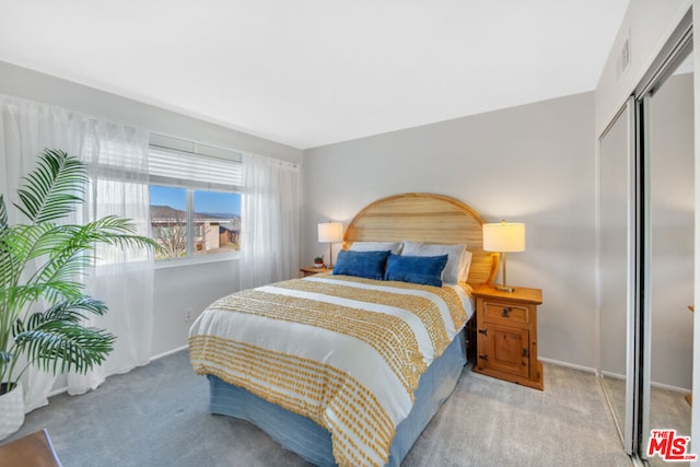 bedroom with light colored carpet and a closet