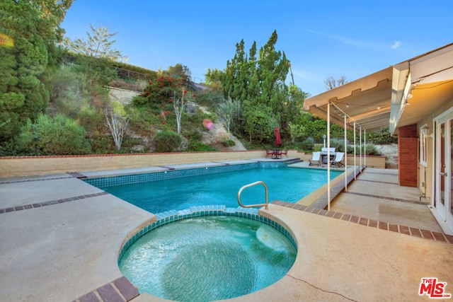 view of swimming pool featuring an in ground hot tub and a patio