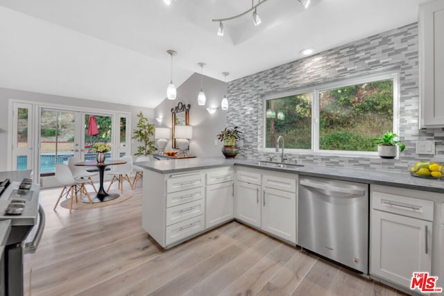 kitchen with stainless steel appliances, white cabinetry, sink, and backsplash