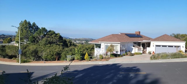 view of front facade featuring a garage and solar panels