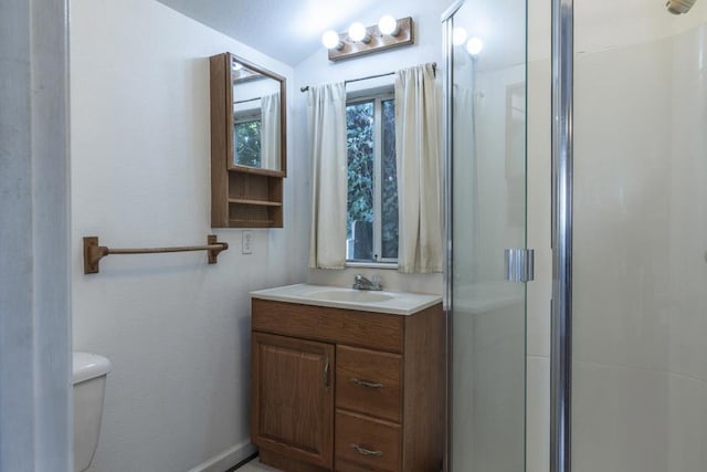 bathroom with a shower with door, vanity, and toilet