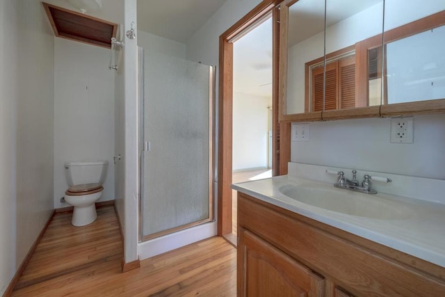 bathroom with vanity, toilet, a shower with shower door, and wood-type flooring