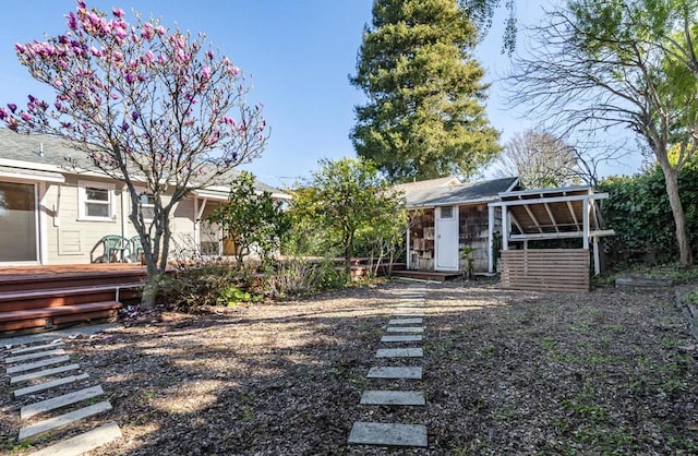 view of yard with a wooden deck and a storage shed