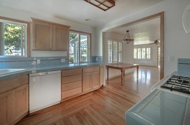 kitchen with pendant lighting, white dishwasher, tile countertops, and light brown cabinets