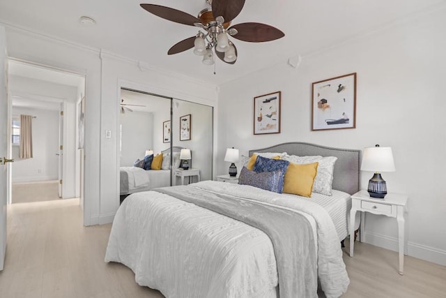 bedroom with ceiling fan, crown molding, light hardwood / wood-style floors, and a closet