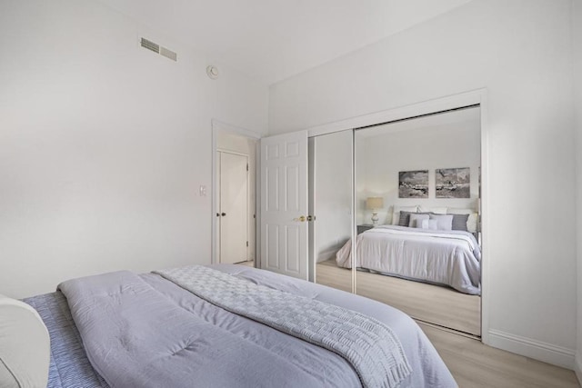 bedroom with light wood-type flooring and a closet