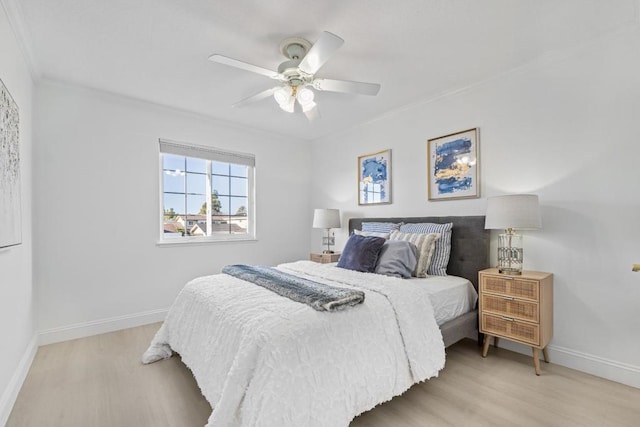 bedroom featuring crown molding, light hardwood / wood-style flooring, and ceiling fan