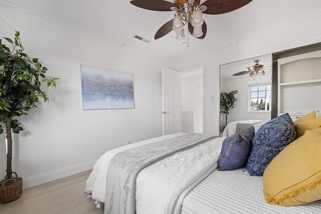 bedroom with crown molding, ceiling fan, and light hardwood / wood-style flooring