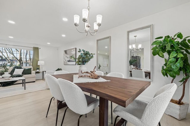 dining area featuring light wood-type flooring and a chandelier