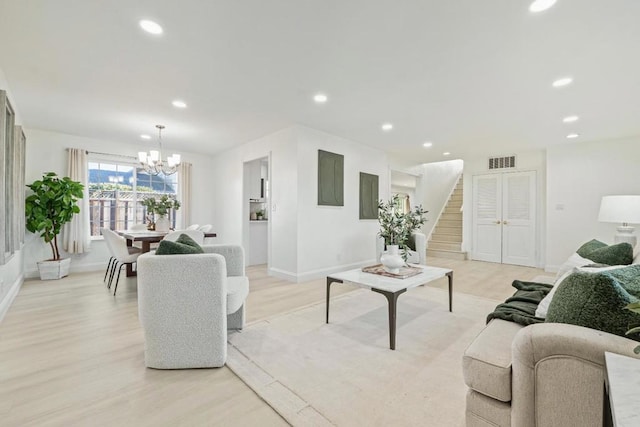 living room featuring an inviting chandelier and light hardwood / wood-style floors