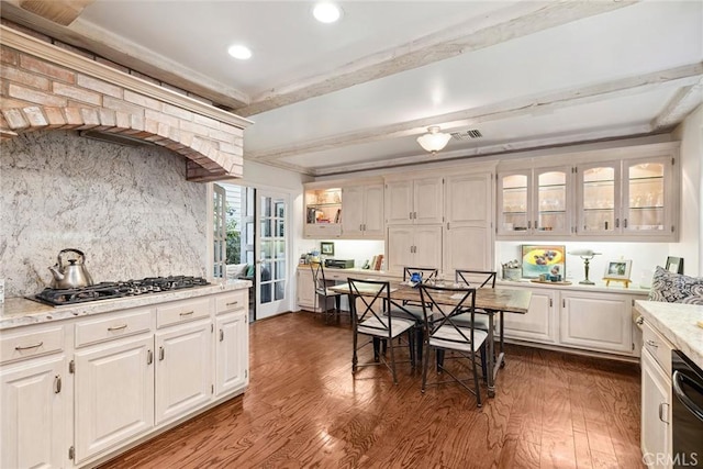 kitchen featuring beamed ceiling, white cabinets, decorative backsplash, stainless steel gas cooktop, and dark wood-type flooring