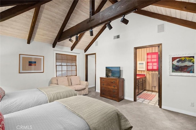 carpeted bedroom featuring beamed ceiling, wood ceiling, rail lighting, and ensuite bathroom