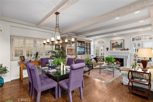 dining area featuring dark hardwood / wood-style flooring, a high end fireplace, a chandelier, and beamed ceiling