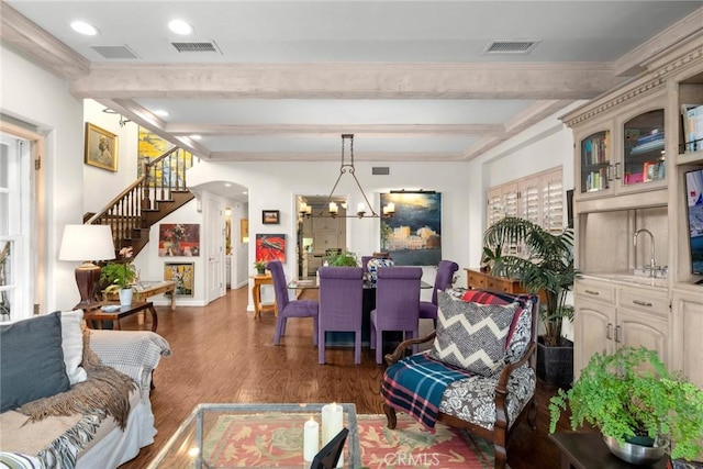 interior space featuring an inviting chandelier, dark wood-type flooring, sink, and beam ceiling