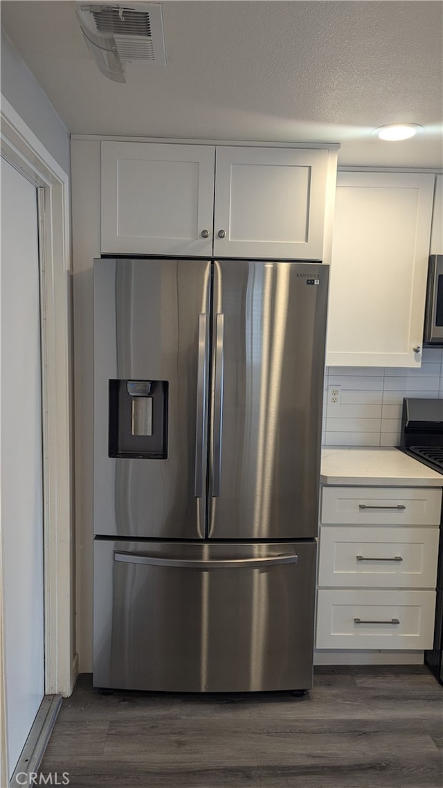 kitchen with white cabinetry, stainless steel appliances, and dark hardwood / wood-style floors