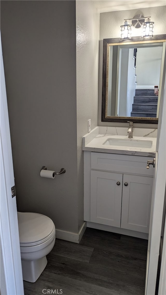 bathroom featuring vanity, toilet, and hardwood / wood-style floors