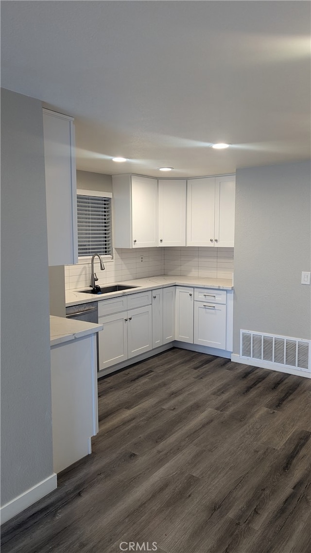 kitchen with white cabinetry, dark hardwood / wood-style flooring, sink, and tasteful backsplash