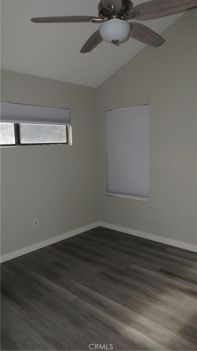 spare room featuring vaulted ceiling, dark hardwood / wood-style floors, and ceiling fan