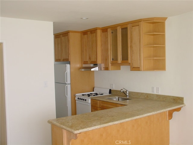 kitchen featuring white appliances, a kitchen bar, kitchen peninsula, and sink