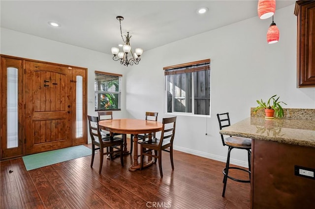 dining area featuring recessed lighting, baseboards, a notable chandelier, and dark wood finished floors