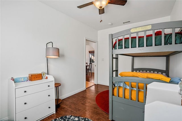 bedroom with visible vents, baseboards, wood finished floors, and arched walkways
