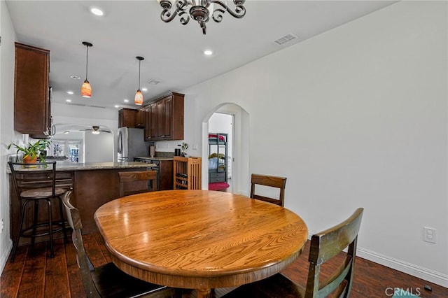 dining room with recessed lighting, baseboards, arched walkways, and dark wood-type flooring
