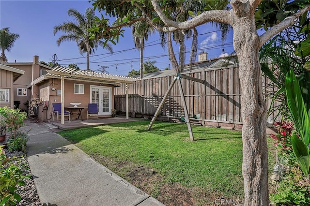 view of yard with a patio area, french doors, and a fenced backyard