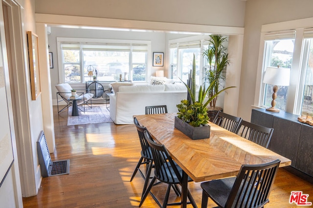 dining area featuring dark wood-type flooring and plenty of natural light