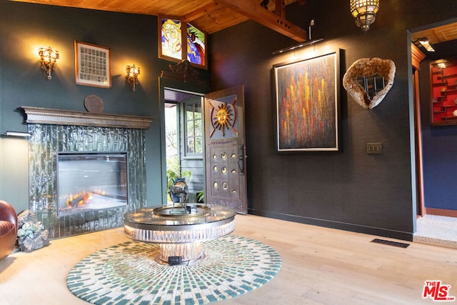 foyer featuring a fireplace, wood ceiling, wood-type flooring, and lofted ceiling with beams