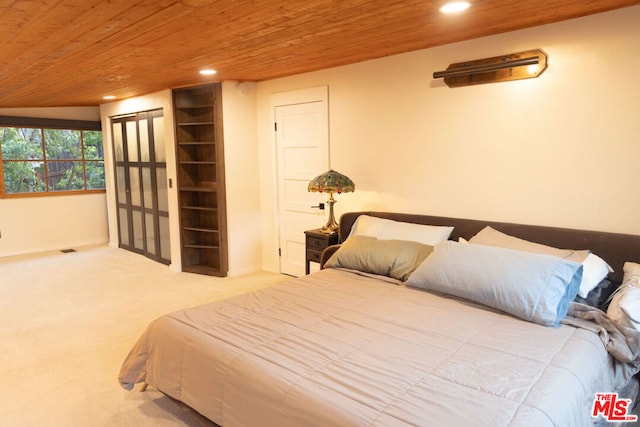 bedroom featuring wood ceiling and carpet floors