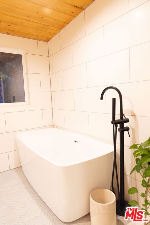 bathroom featuring a bathing tub and wooden ceiling