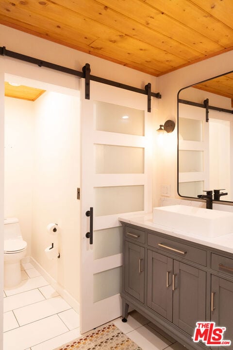 bathroom featuring vanity, toilet, tile patterned flooring, and wooden ceiling