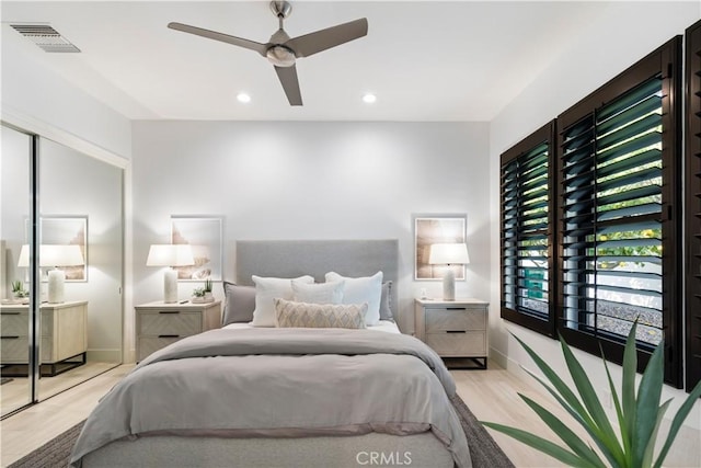 bedroom with ceiling fan, light hardwood / wood-style floors, and a closet