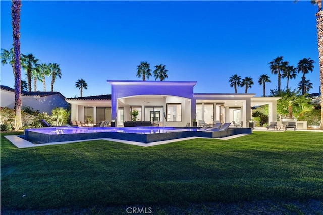 rear view of property with french doors, ceiling fan, a patio, and a lawn