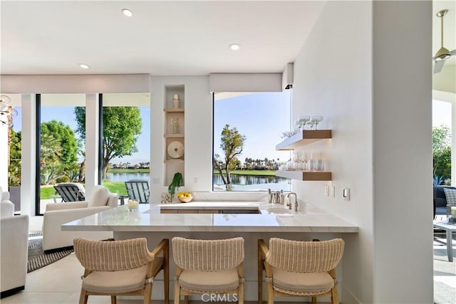 kitchen with a water view, a breakfast bar, and kitchen peninsula