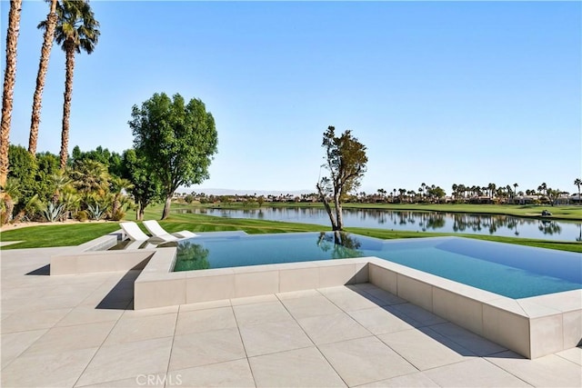 view of swimming pool with a patio area and a water view