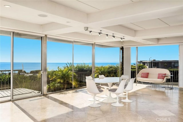 sunroom / solarium featuring a water view and a healthy amount of sunlight