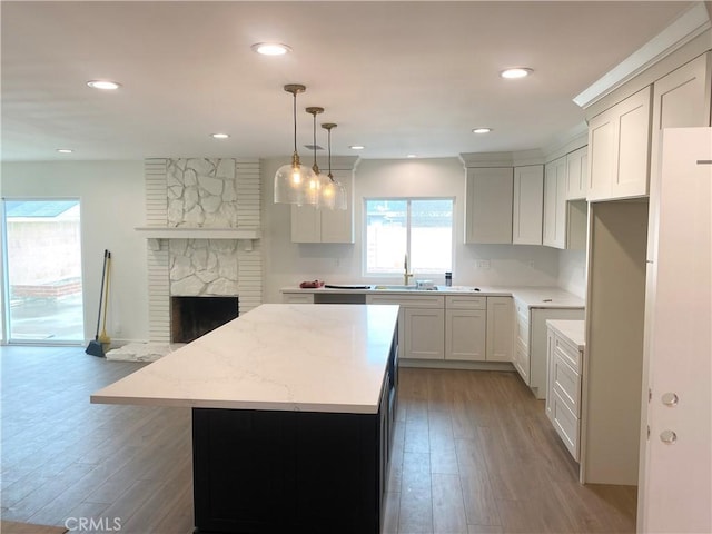 kitchen featuring white cabinetry, decorative light fixtures, light hardwood / wood-style floors, and a center island