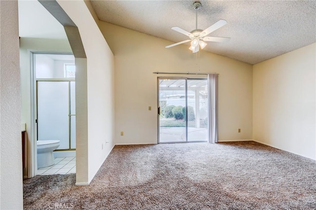 empty room featuring ceiling fan, lofted ceiling, light carpet, and a textured ceiling